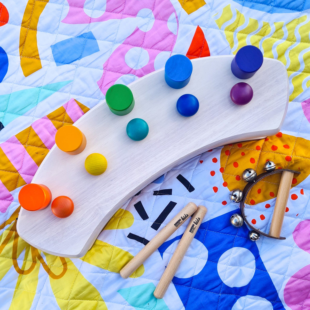 close-up of wooden toys on the quilted pop pip pow large waterproof playmat