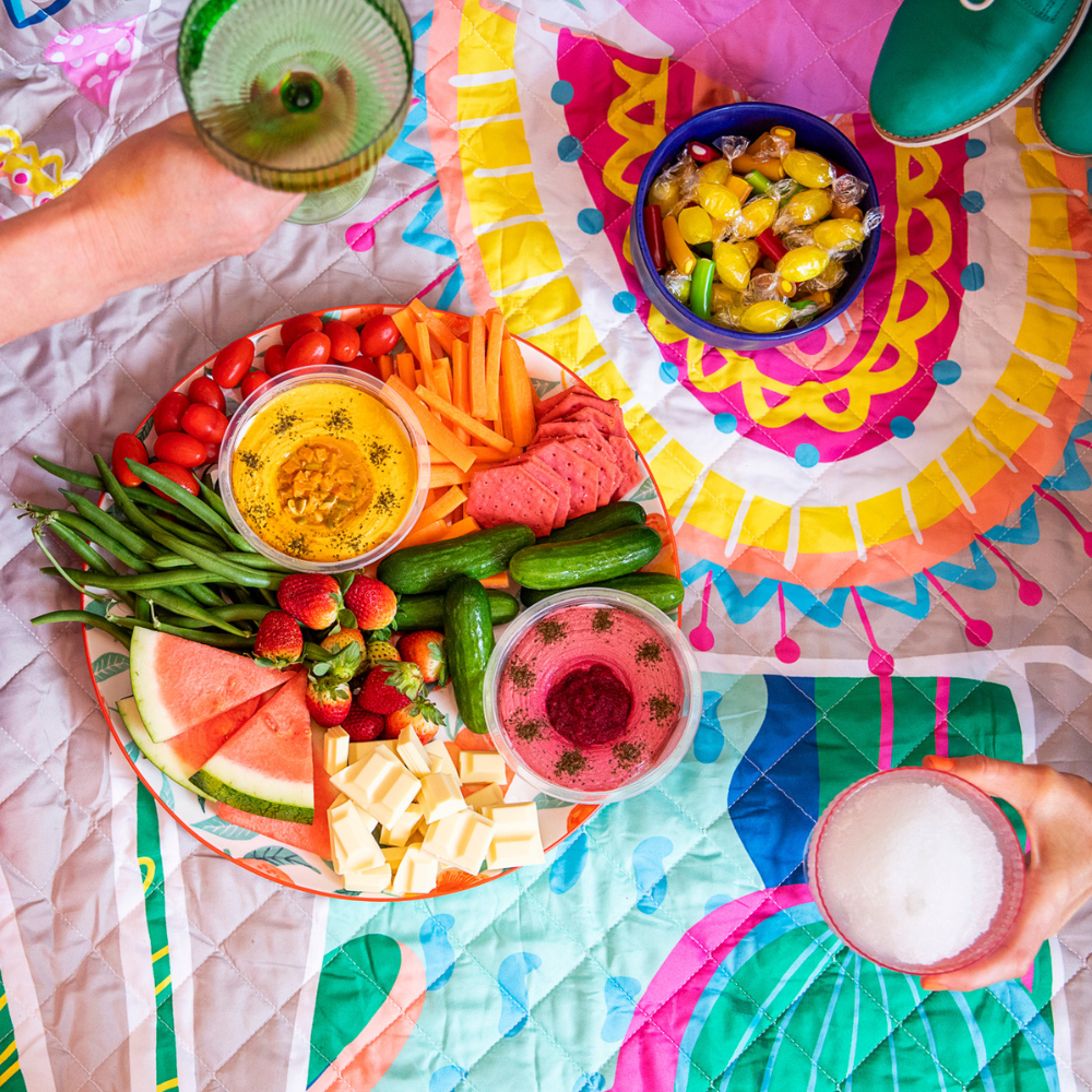 picnic blanket with colourful food for friends