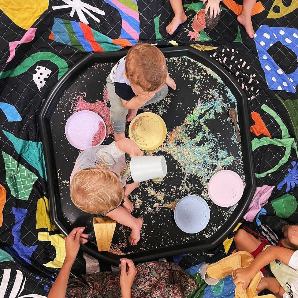 kids playing on black messy play mat