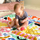 baby on colourful play mat perfect for nappy free time