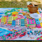 la dolce vita waterproof picnic blanket laid out on the grass with a picnic basket and sun hat