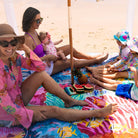 family relaxing at the beach on the octopus's garden picnic blanket with umbrella hole