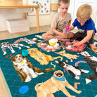 two children playing on the pooch party large waterproof mat at home