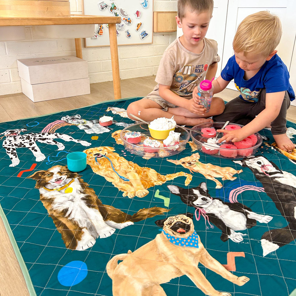 two children playing on the pooch party large waterproof mat at home