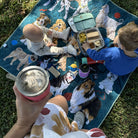 overhead view of children eating lunch on the pooch party large waterproof mat on the grass