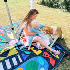 mother with baby and dog under a cabana on the rock candy picnic blanket with umbrella hole