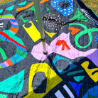close-up of an umbrella pole through the middle of the rock candy picnic blanket with umbrella hole