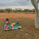 children having a picnic on the happy now large waterproof playmat under a gum tree in the outback