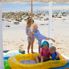 children playing in an inflatable pool under a cabana on the happy now picnic blanket with umbrella hole